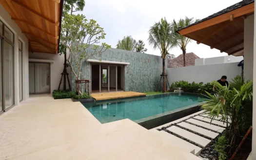 Открытый бассейн с деревянной террасой и тропическими растениями