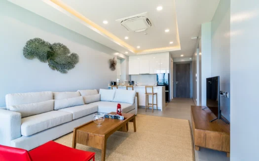 Гостиная с голубыми стенами, бежевым диваном и зелёной настенной скульптурой