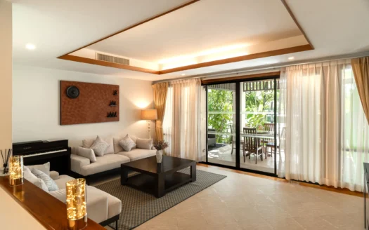 Яркая гостиная с бежевым диваном и стеклянными дверями на террасу