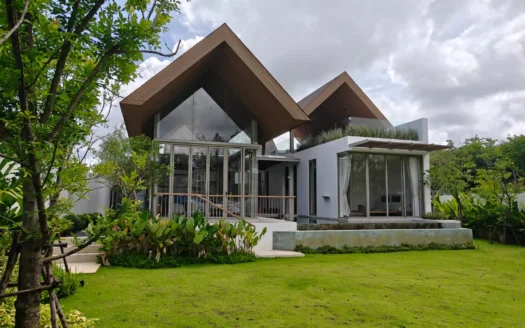 Современная вилла с деревянными скатными крышами A-frame, стеклянными стенами и пышным газоном