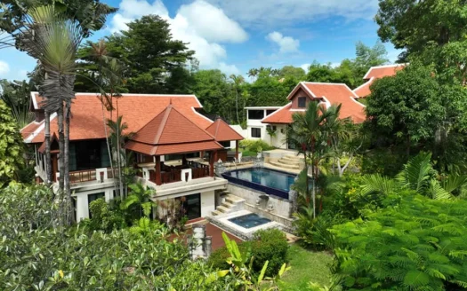 Солнечный тропический комплекс вилл с красной черепичной крышей и бассейном