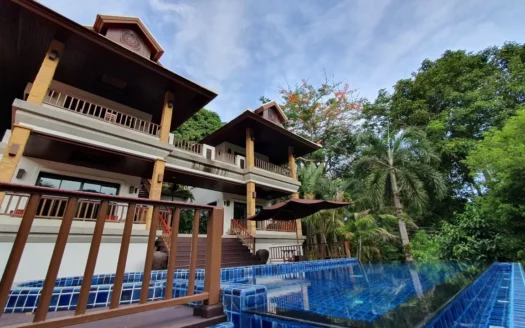 Двухэтажная вилла с бассейном в голубой плитке и пальмами