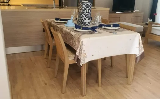 Открытая кухня-столовая с деревянным полом и вазой