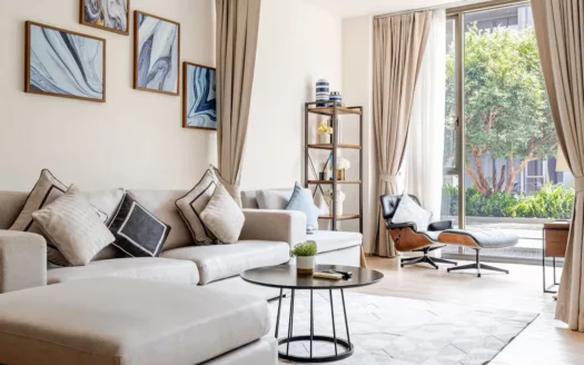 Светлая гостиная с белым угловым диваном и большим окном