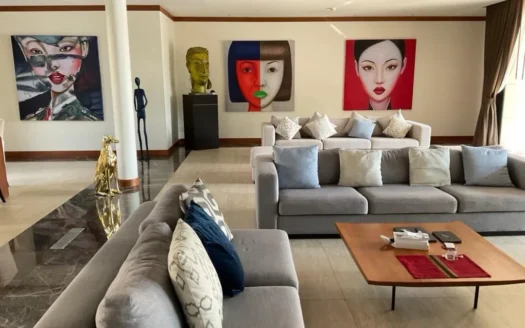 Яркая гостиная с серым модульным диваном и абстрактным искусством на стенах