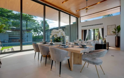 Яркая столовая с панорамными стеклянными стенами, деревянным потолком и орхидеей в центре