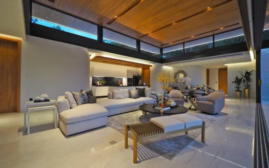 Гостиная с открытой планировкой, бежевым диваном и деревянным потолком