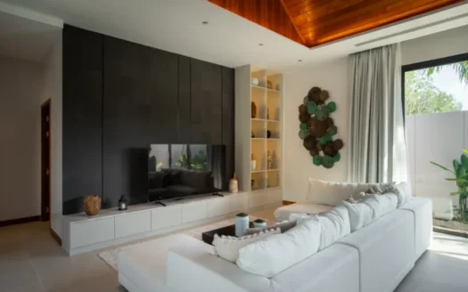 Яркая гостиная с белым угловым диваном, темной панелированной стеной и полками