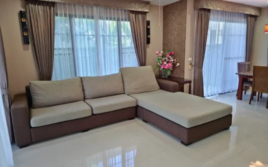 Гостиная с угловым бежево-коричневым диваном у больших окон