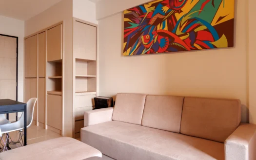 Гостиная с бежевым диваном и абстрактной яркой картиной