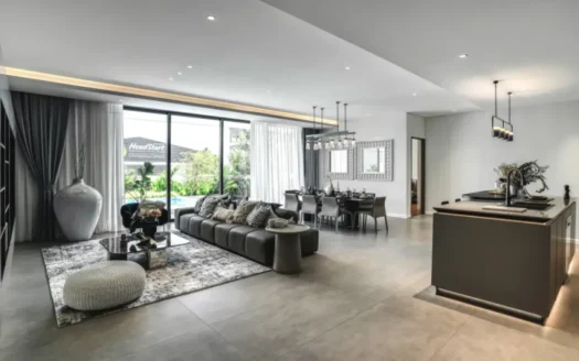 Открытая гостиная с серым угловым диваном и стеклянными дверями