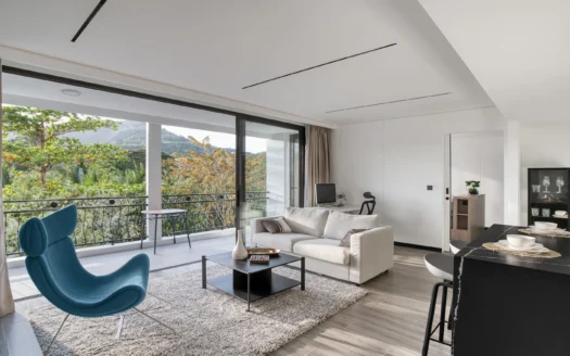 Яркая гостиная с синим акцентным креслом и большими стеклянными балконными дверями