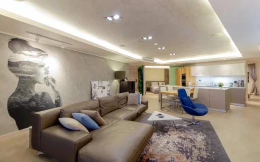 Просторная гостиная с коричневым кожаным диваном и синим креслом