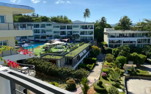 Солнечный двор курорта с белыми зданиями бассейном и пальмами