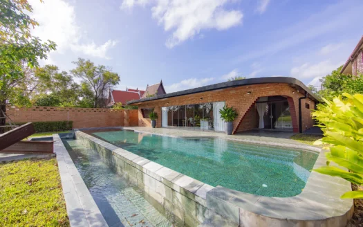 Уличный вид кирпичного особняка с длинным бассейном и стеклянными дверями