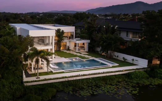 Современная белая вилла с прямоугольным бассейном и пальмами на закате