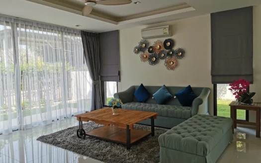 Яркая гостиная с зелёным диваном и прозрачными занавесками