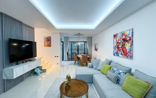 Яркая гостиная с серым угловым диваном и красочной картиной