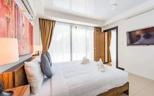 Яркая гостиничная спальня с белым постельным бельём и телевизором на стене