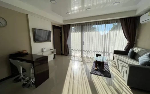 Яркая гостиная с диваном, стеклянным кофейным столиком и телевизором