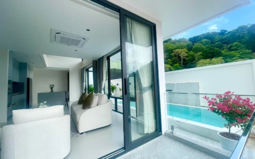 Яркая дневная гостиная с белым диваном и стеклянным балконом, смотрящим на бассейн