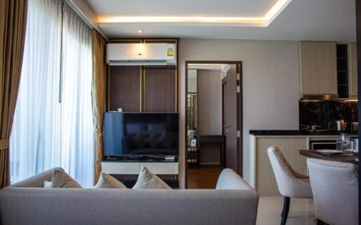 Гостиная с диваном, телевизором и открытой кухней