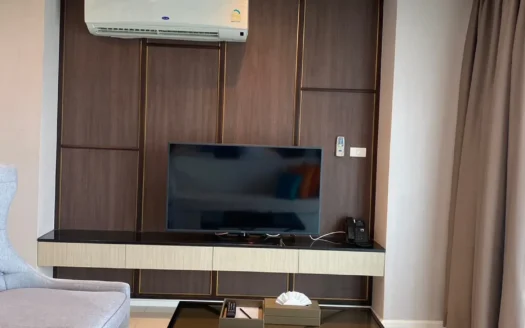 Современная гостиная с темной деревянной стеной и телевизором