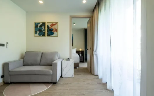 Гостиная с серым диваном и мраморным столиком у больших окон