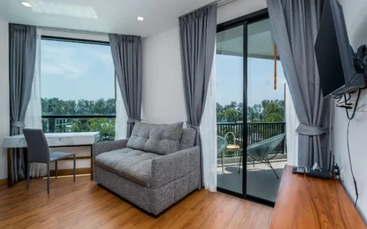 Гостиная с серым диваном, столом и видом на балкон