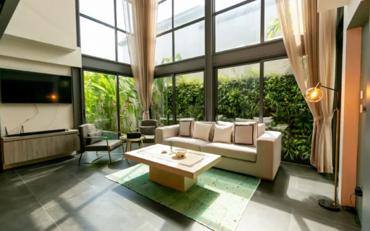 Яркая гостиная с панорамными стеклянными стенами и зеленью