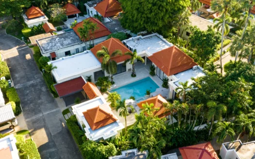 Аэросъемка комплекса вилл с оранжевыми крышами и бассейном