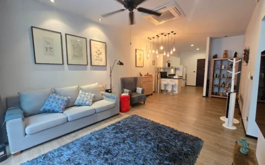 Светлая гостиная в открытой планировке с серым диваном и кухонным островом