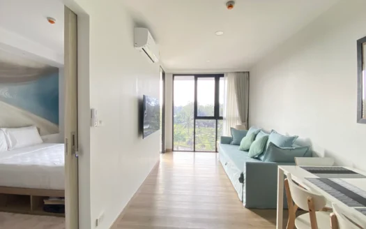 Гостиная с светло‑бирюзовым диваном и видом на балкон