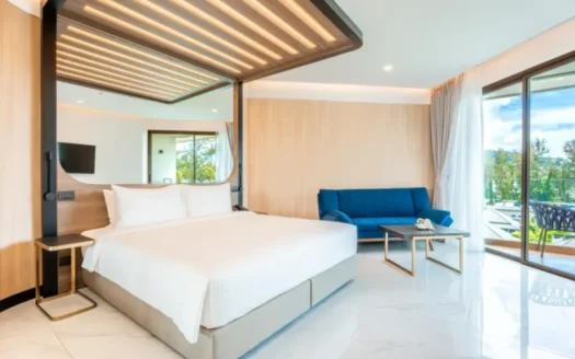 Спальня с белой кроватью деревянным навесом синим диваном