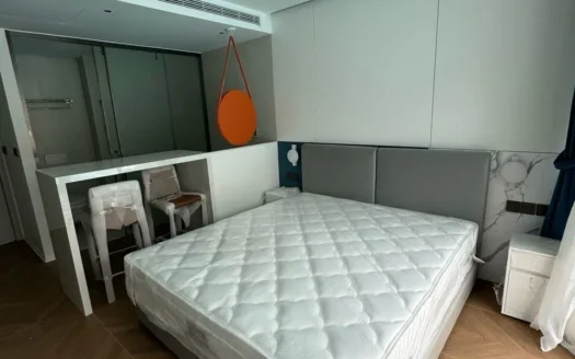 Спальня с серым изголовьем кровати, белым матрасом и оранжевым круглыm зеркалом