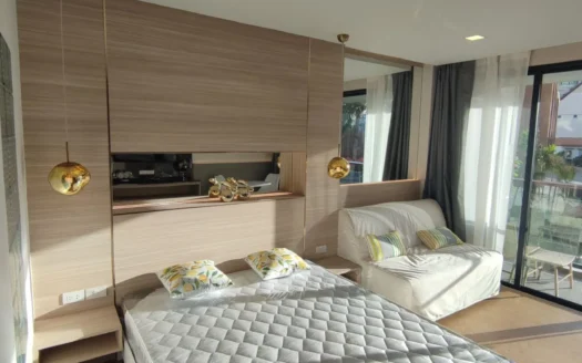 Спальня с дерево-панелью на стене, кроватью и золотыми подвесными светильниками