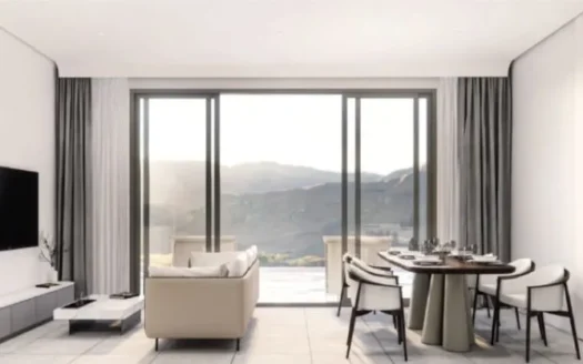 Яркая гостиная с бежевым диваном и круглым столом у окна на горы