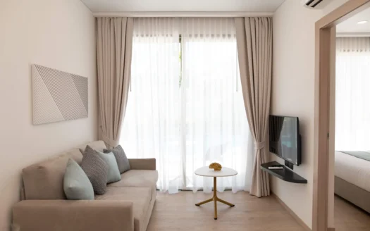 Яркая гостиная с бежевым диваном и прозрачными занавесками