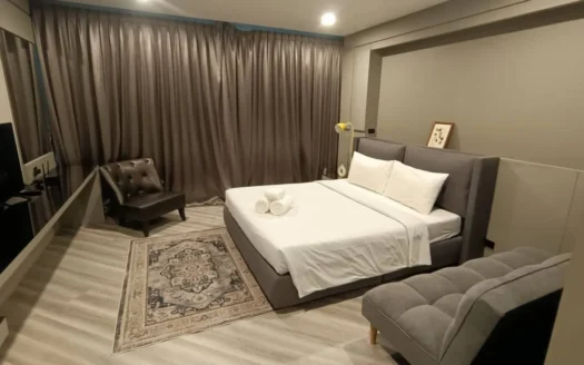 Современная серая спальня с большой кроватью и зоной отдыха