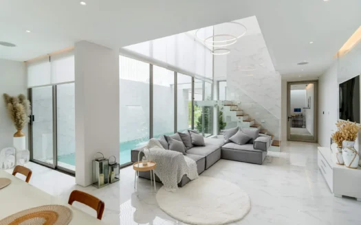 Яркая гостиная с мраморным полом и стеклянным видом на бассейн