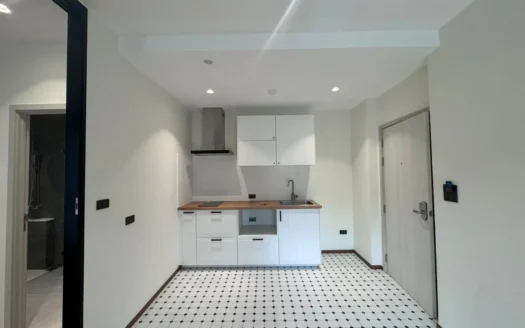 Маленькая современная кухня с белыми шкафами и деревянной столешницей