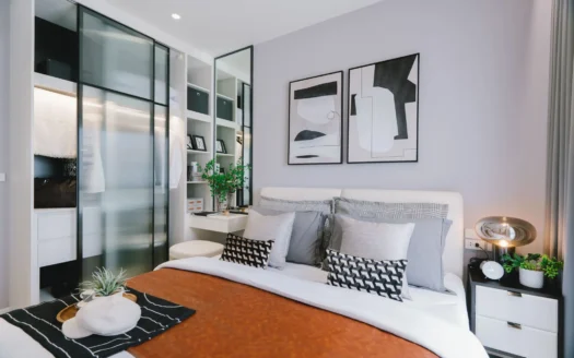 Современная спальня с серыми стенами, белым изголовьем, абстрактное искусство