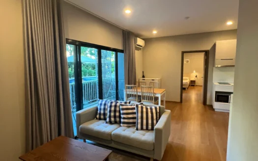 Уютная гостиная с светло-серым диваном и синими полосатыми подушками