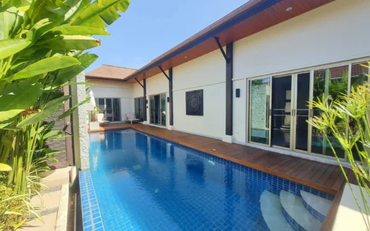 Уличный двор виллы с бассейном в голубой плитке и раздвижными дверями