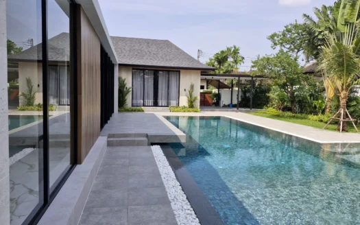 Современная вилла с стеклянными стенами и длинным бассейном