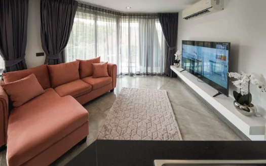 Гостиная с коралловым диваном, прозрачными занавесками и большими окнами