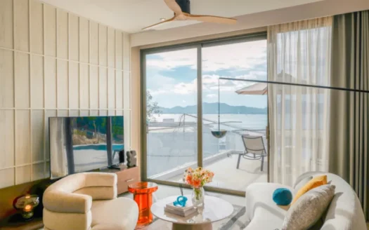 Гостиная с белым диваном и видом на воду с балкона