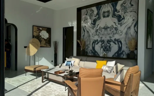 Яркая гостиная с бежевыми кожаными креслами и большим абстрактным настенным рисунком