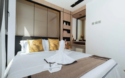 Яркая спальня с деревянной панелью шкафа и золотыми подушками с пальмовым узором