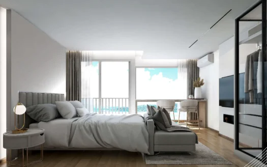 Спальня с серой кроватью перед окнами с видом на океан